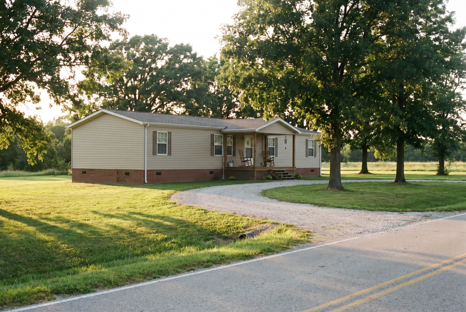 A double-wide manufactured home on a permanent foundation with brick skirting and a covered porch